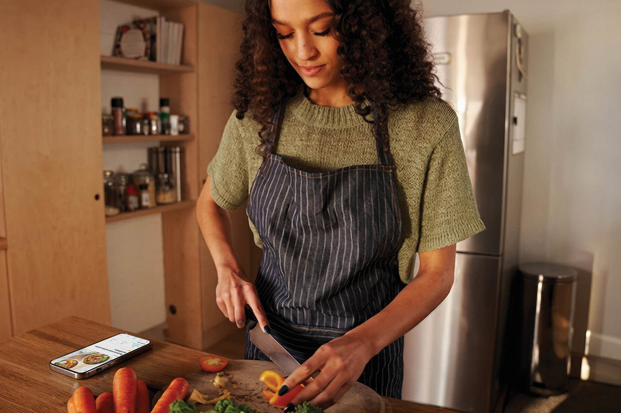 Femme cuisinant avec l’app Xtra ouverte